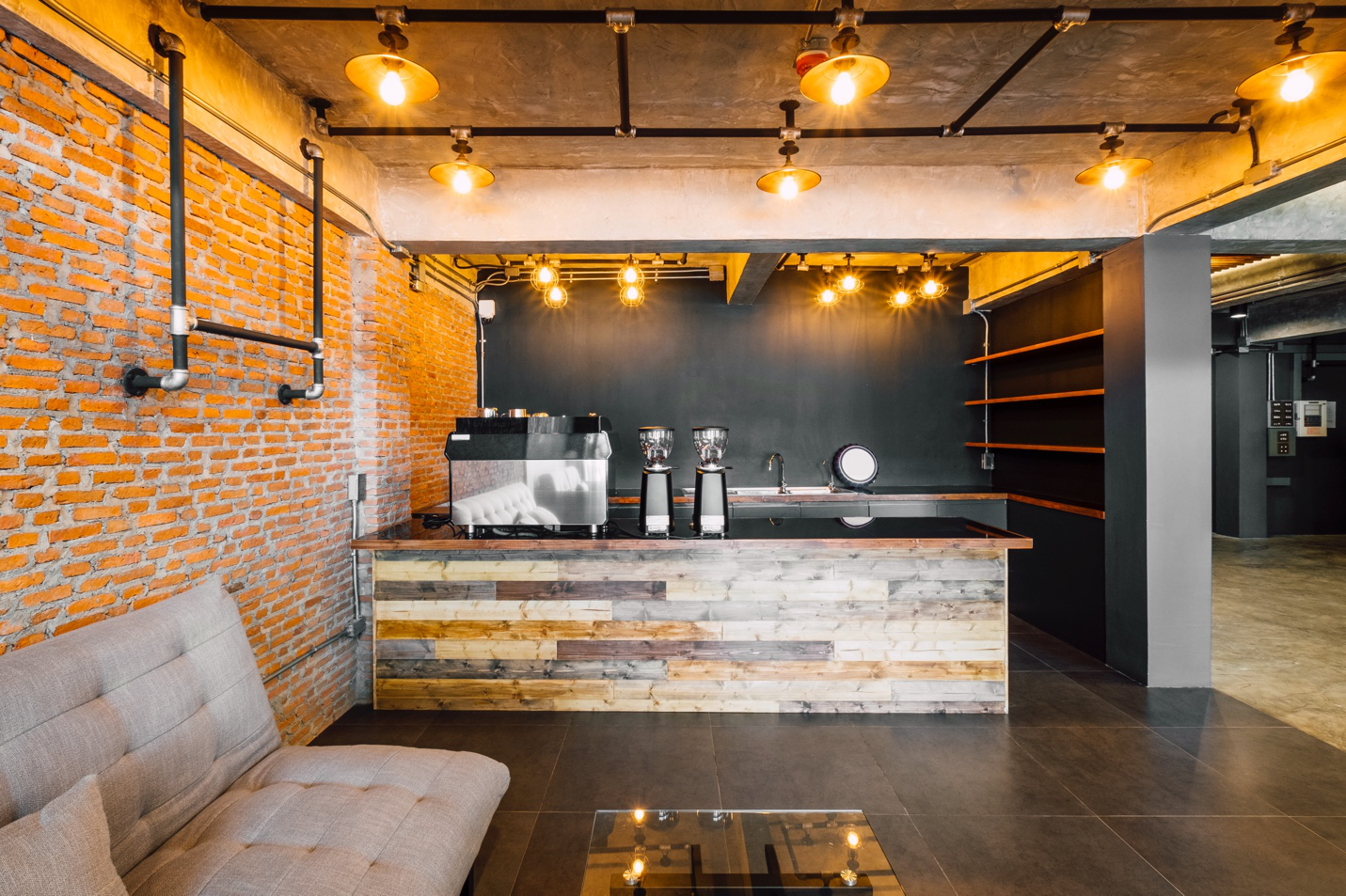 Tampa Flooring | Choosing the Right Flooring for Commercial Spaces: What Tampa Business Owners Need to Know A large industrial chic space with black wood tile, distressed wood and sofa