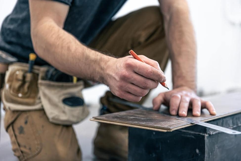 Professional flooring contractor measuring tile for installation.